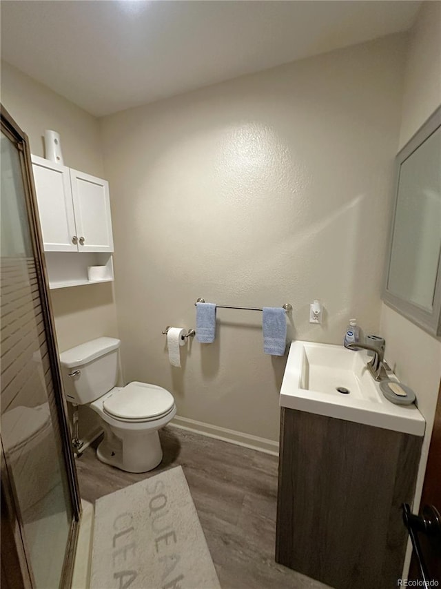 495 E Ave, Limon, CO 80828 - full bathroom featuring wood finished floors, toilet, vanity, a shower stall, and baseboards