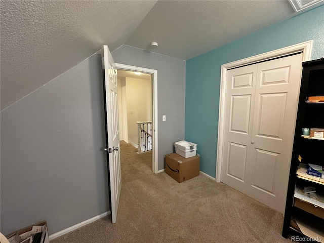 495 E Ave, Limon, CO 80828 - unfurnished bedroom with carpet floors, lofted ceiling, a textured ceiling, and a closet