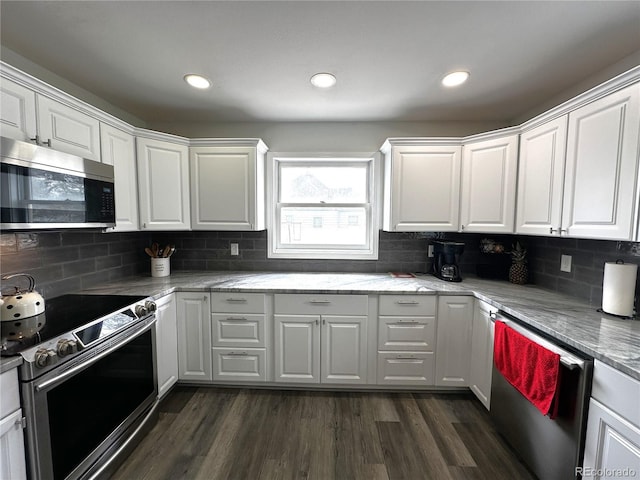 495 E Ave, Limon, CO 80828 - kitchen featuring appliances with stainless steel finishes, white cabinetry, dark wood finished floors, tasteful backsplash, and recessed lighting