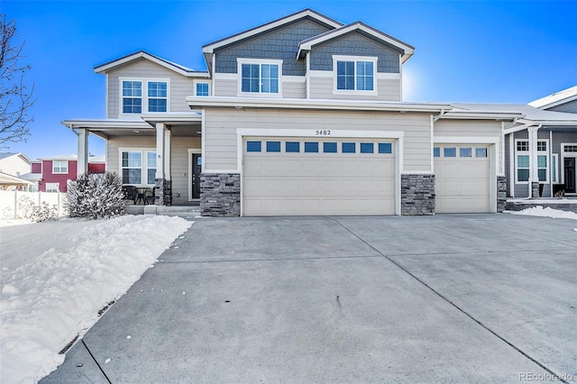 view of front of property with a garage, concrete driveway, a porch, and stone siding