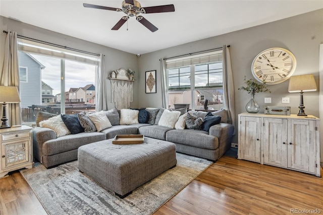 living area with light wood finished floors and a ceiling fan