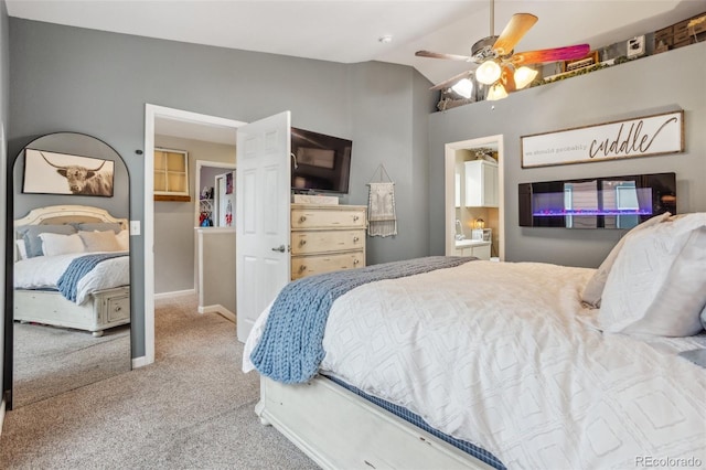 bedroom featuring lofted ceiling, ensuite bathroom, carpet flooring, a ceiling fan, and baseboards