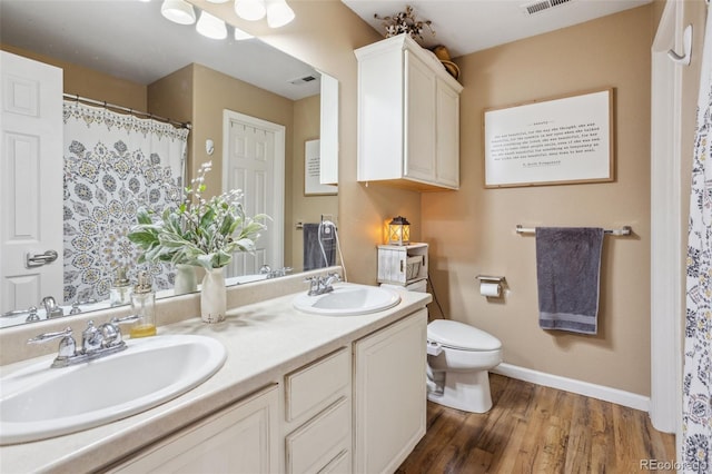 full bath featuring visible vents, a sink, toilet, and wood finished floors