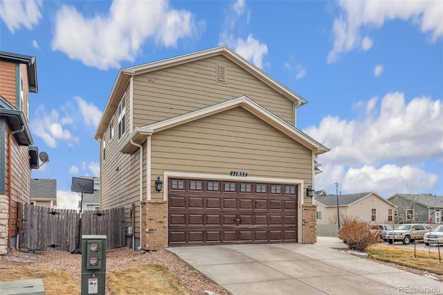 traditional-style house with a garage, brick siding, and fence