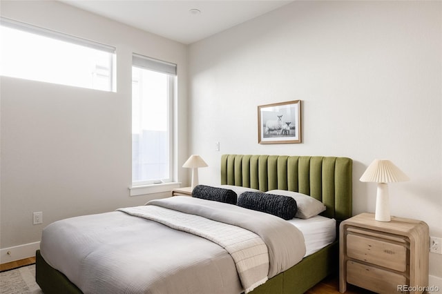 bedroom with hardwood / wood-style floors and multiple windows