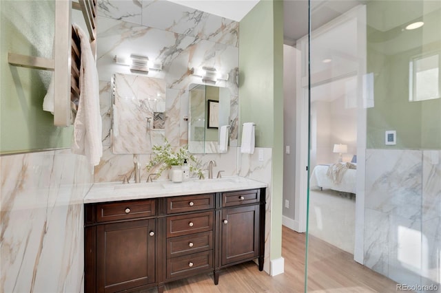 bathroom with vanity, hardwood / wood-style floors, and tile walls