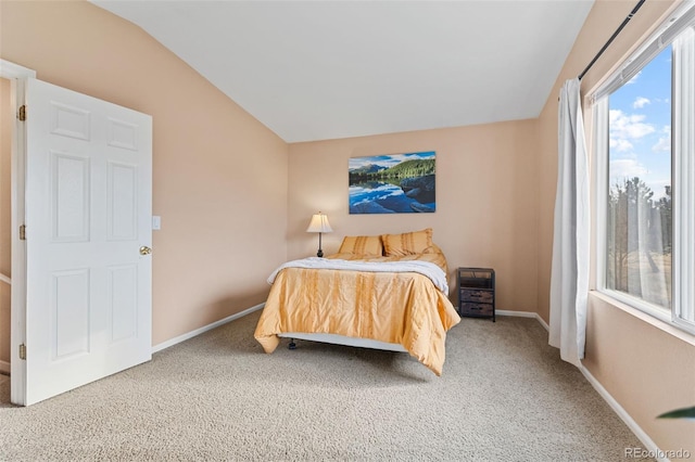 carpeted bedroom with lofted ceiling and baseboards