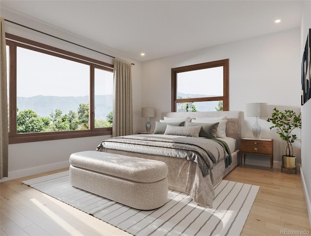 bedroom featuring recessed lighting, light wood-type flooring, a mountain view, and baseboards