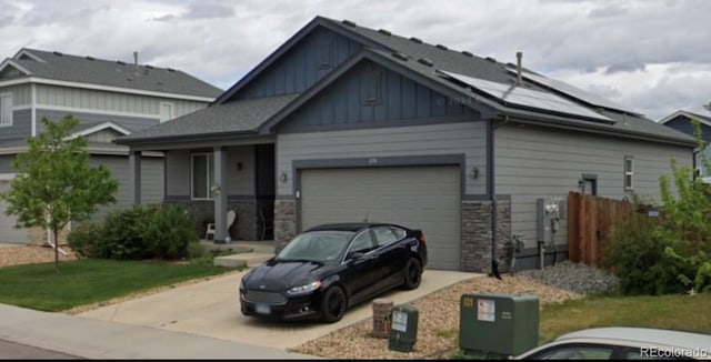 view of front facade with solar panels, a garage, board and batten siding, and concrete driveway
