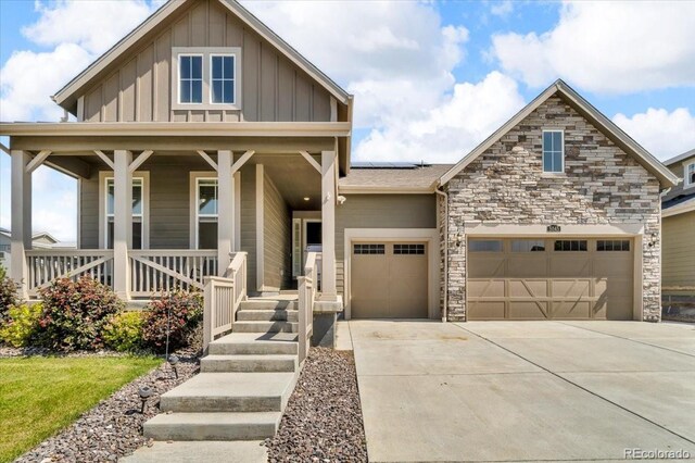 5045 Preserve Pl, Firestone, CO 80504 - craftsman-style home with covered porch, an attached garage, driveway, board and batten siding, and solar panels