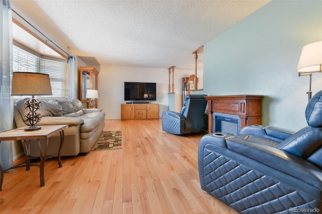 living room with light wood-type flooring and a textured ceiling