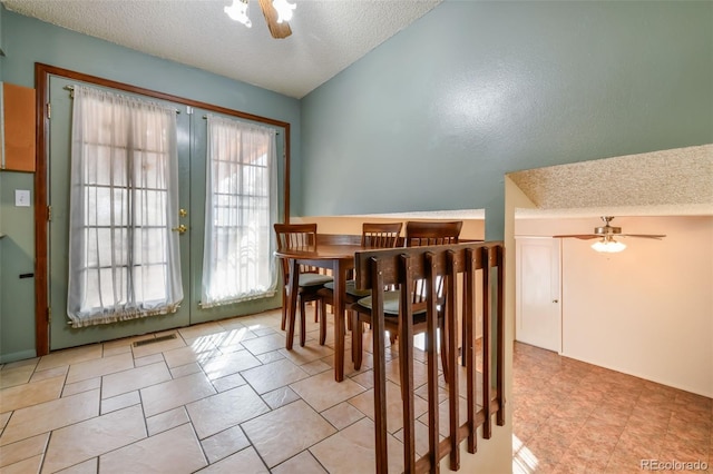 dining area featuring a textured ceiling, french doors, vaulted ceiling, and ceiling fan