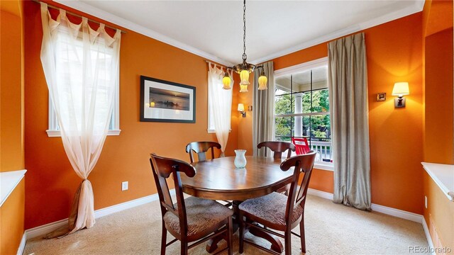 dining space with carpet flooring, baseboards, and crown molding