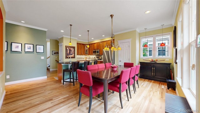dining space featuring recessed lighting, light wood-type flooring, baseboards, and crown molding