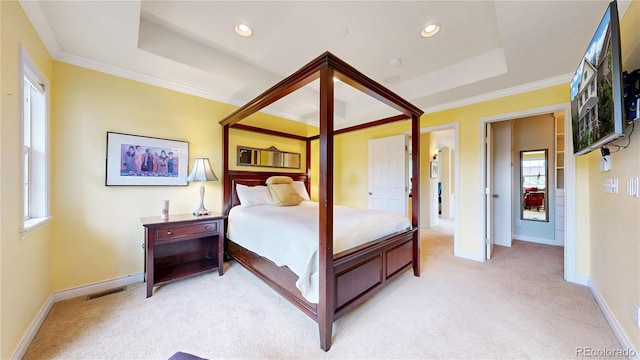 bedroom with light colored carpet, baseboards, ornamental molding, recessed lighting, and a tray ceiling
