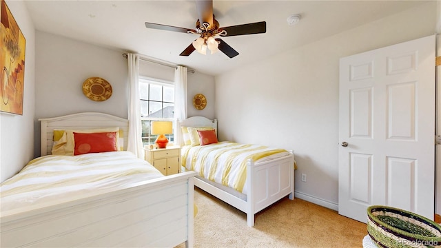bedroom featuring light colored carpet, ceiling fan, and baseboards