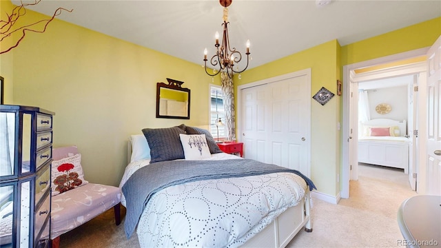 bedroom featuring a chandelier, light carpet, a closet, and baseboards