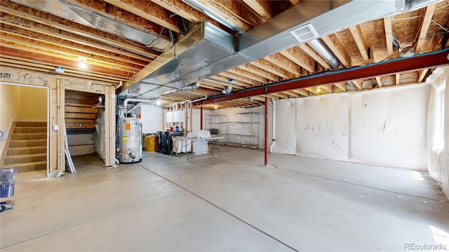 unfinished below grade area featuring stairway and gas water heater