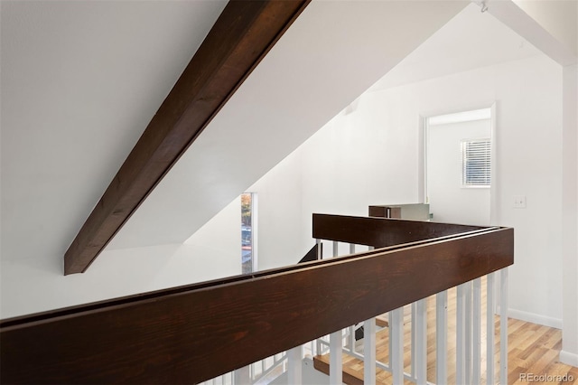 staircase featuring hardwood / wood-style flooring and beamed ceiling