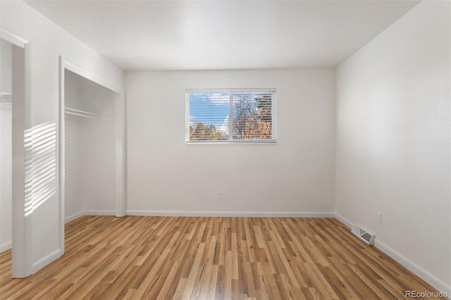 unfurnished bedroom featuring light hardwood / wood-style floors and a closet