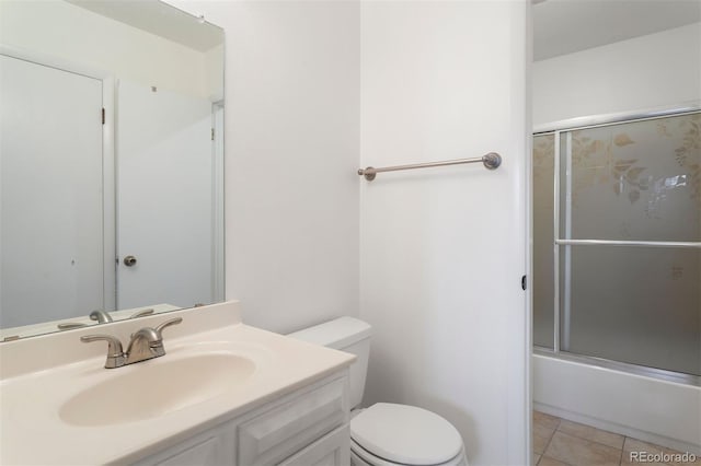 full bathroom featuring vanity, combined bath / shower with glass door, tile patterned floors, and toilet