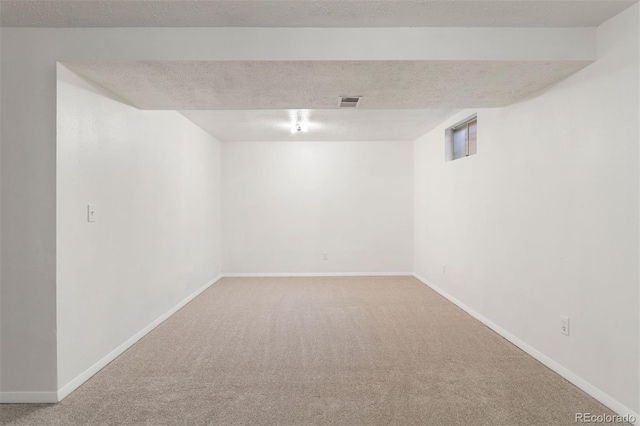 basement featuring a textured ceiling and carpet