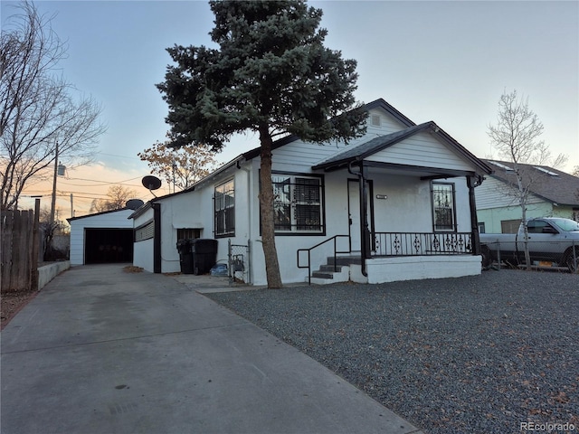 view of front of home featuring a porch, a garage, and an outdoor structure