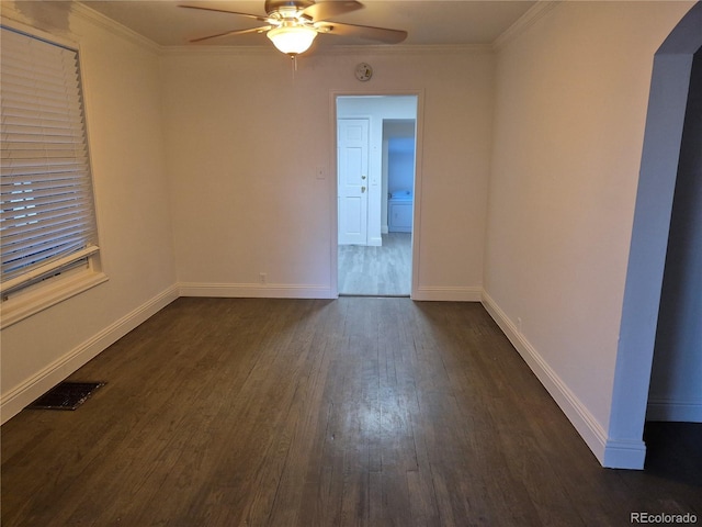 empty room featuring ceiling fan, dark wood-type flooring, and ornamental molding