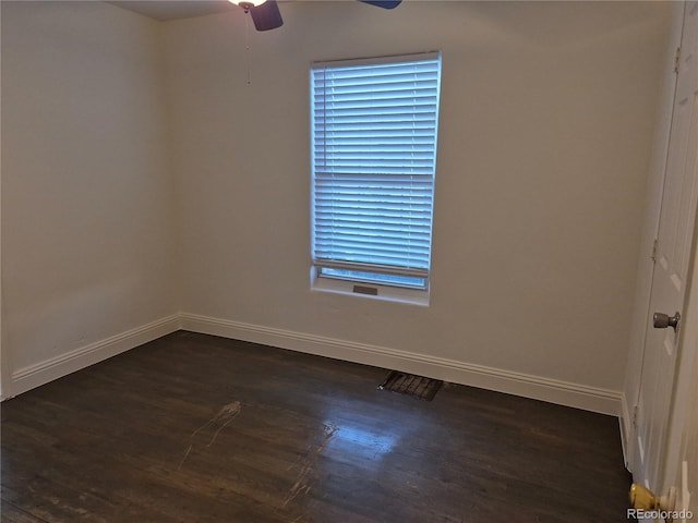 empty room with ceiling fan and dark hardwood / wood-style flooring