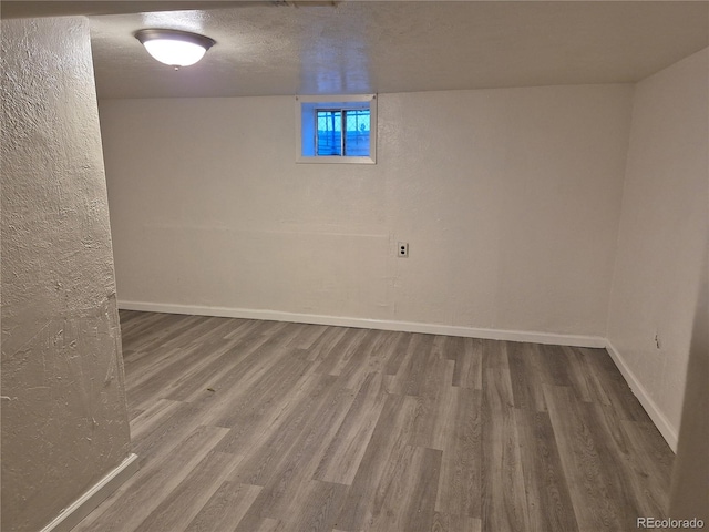 basement with a textured ceiling and hardwood / wood-style flooring