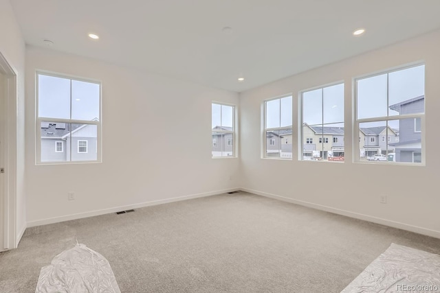 unfurnished room featuring baseboards, visible vents, recessed lighting, and light colored carpet