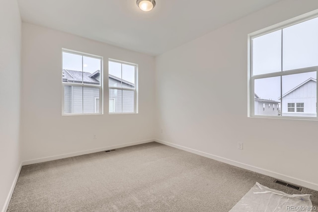 unfurnished room featuring baseboards, carpet, and visible vents