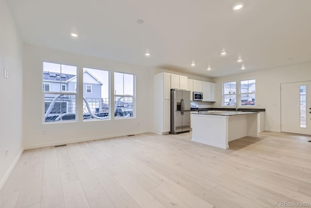 kitchen featuring visible vents, dark countertops, baseboards, white cabinets, and stainless steel appliances