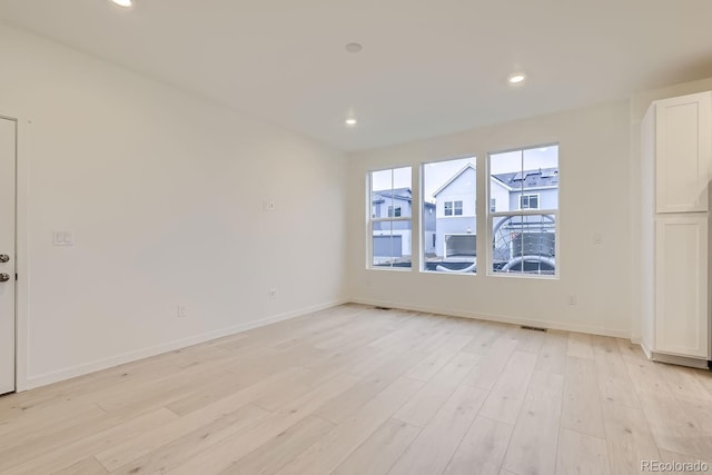 unfurnished room with baseboards, recessed lighting, and light wood finished floors