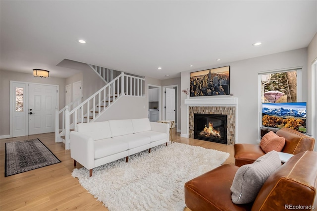 living room with light wood-style floors, recessed lighting, a fireplace, and stairway