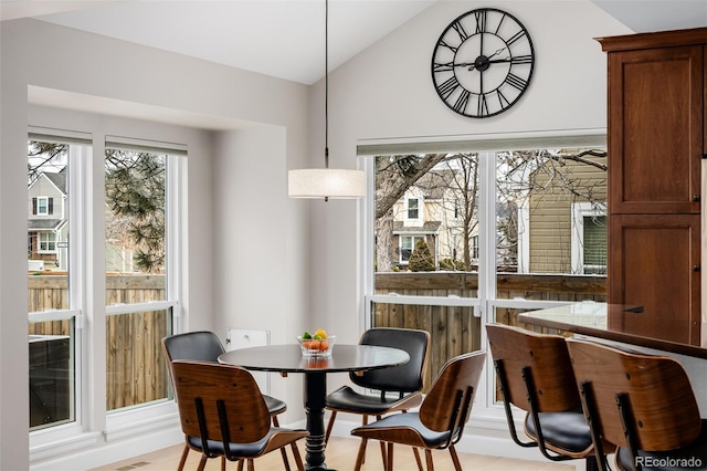 dining area with vaulted ceiling, plenty of natural light, and light wood finished floors