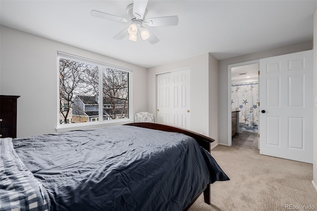 bedroom featuring light carpet, a closet, connected bathroom, and a ceiling fan