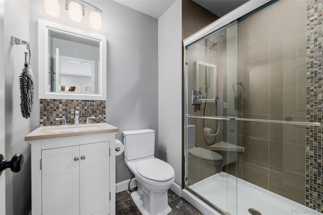 bathroom with baseboards, decorative backsplash, toilet, vanity, and a shower stall