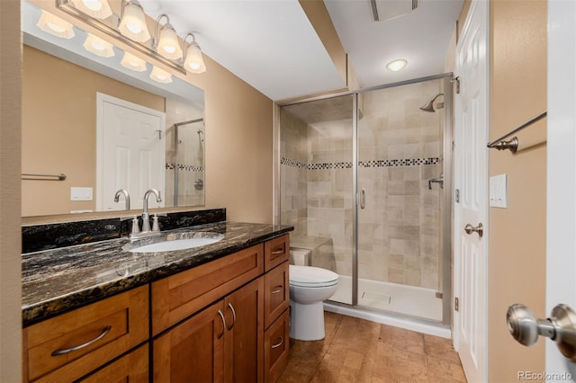 bathroom featuring visible vents, toilet, a shower stall, and vanity