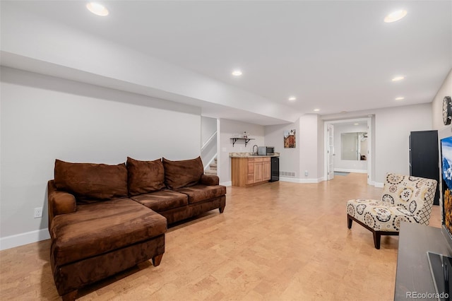 living area with recessed lighting, bar, baseboards, and stairs