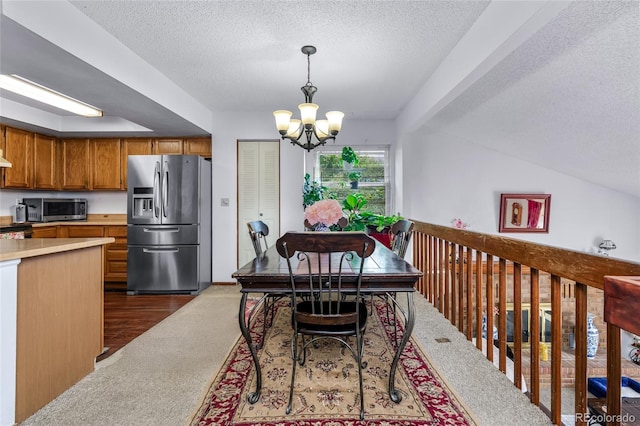 18771 Mexico Dr E, Aurora, CO 80017 - dining area with dark carpet, a chandelier, and a textured ceiling