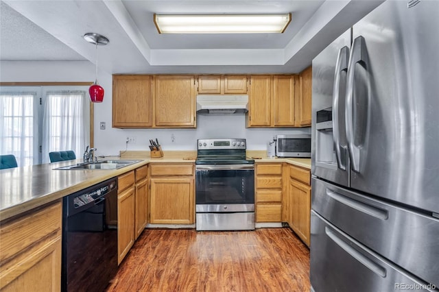18771 Mexico Dr E, Aurora, CO 80017 - kitchen featuring stainless steel appliances, under cabinet range hood, a sink, wood finished floors, and decorative light fixtures