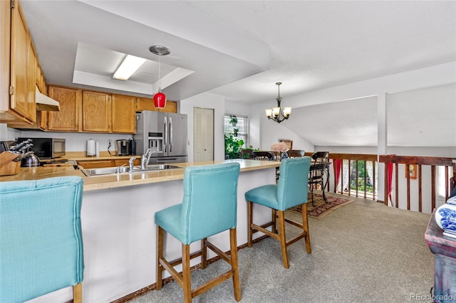 18771 Mexico Dr E, Aurora, CO 80017 - kitchen featuring stainless steel fridge, healthy amount of natural light, a peninsula, and light colored carpet