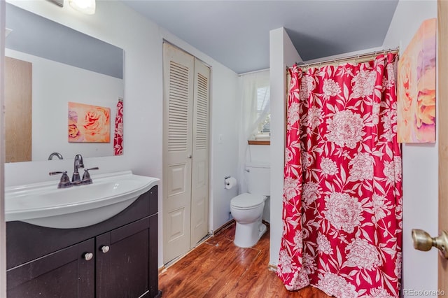 18771 Mexico Dr E, Aurora, CO 80017 - full bathroom featuring a closet, toilet, vanity, wood finished floors, and curtained shower