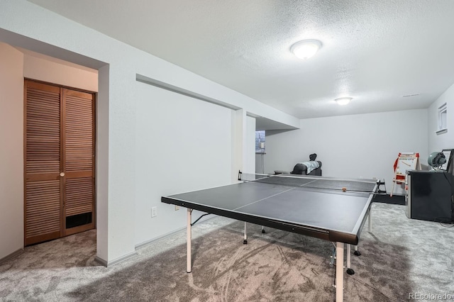 game room with a textured ceiling and carpet floors