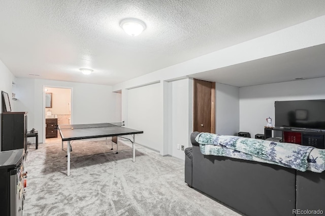 game room featuring a textured ceiling and light colored carpet