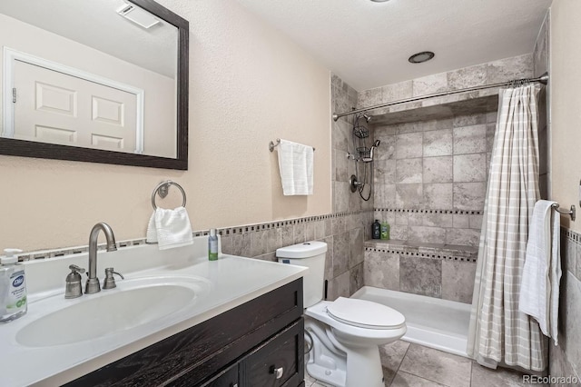 bathroom with vanity, a shower with shower curtain, tile patterned flooring, toilet, and tile walls