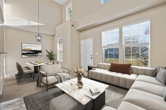 living room with a towering ceiling and dark colored carpet