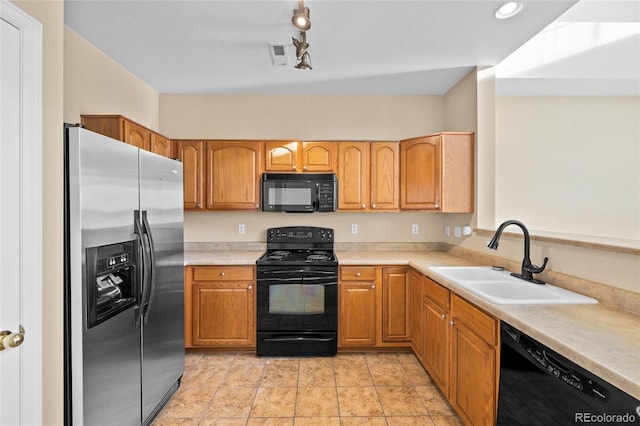 kitchen featuring light tile patterned flooring, sink, and black appliances