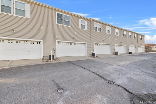 exterior space with a garage and central AC unit